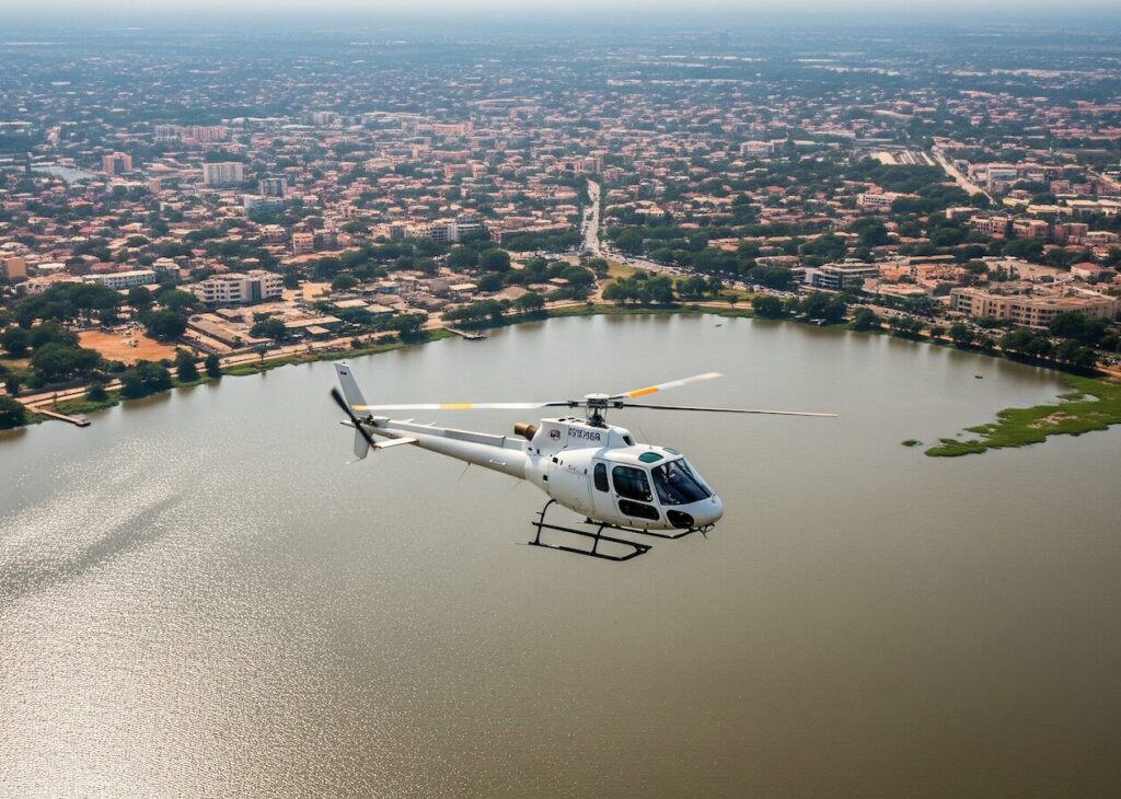 hélicoptère H125 survolant la lagune Ébrié, toits d’Abidjan en arrière-plan